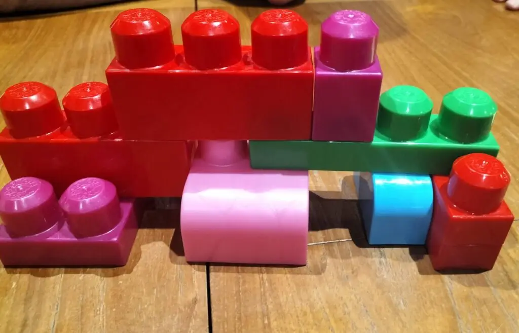 A photo of brightly coloured building blocks stacked on a table.